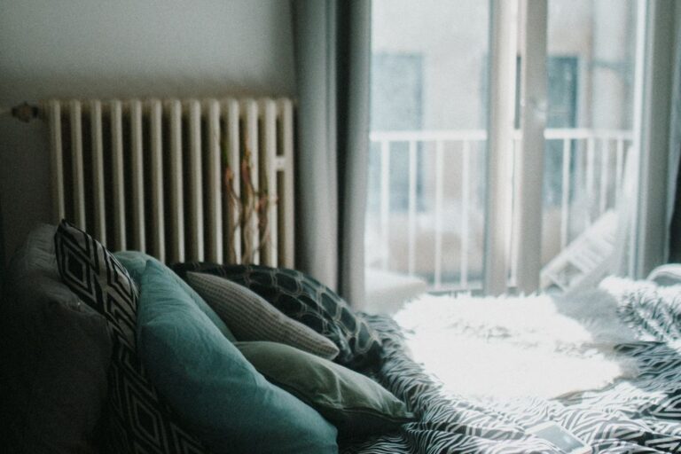 Sunlit bed with pillows in a quiet bedroom